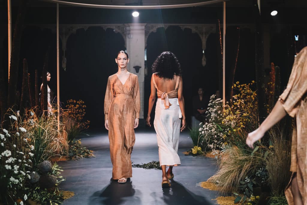 models walking down a runway bordered by dried flowers at Melbourne Fashion Week