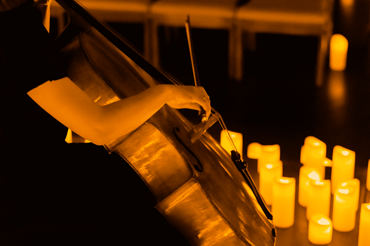 Musician playing a cello by candlelight