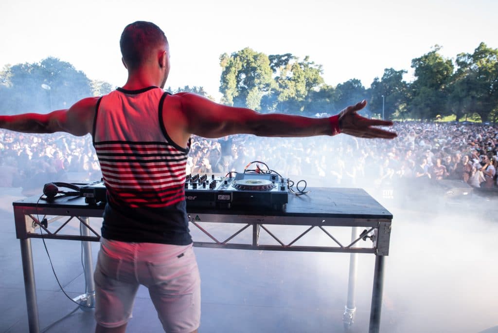 A DJ in front of a crowd outdoors
