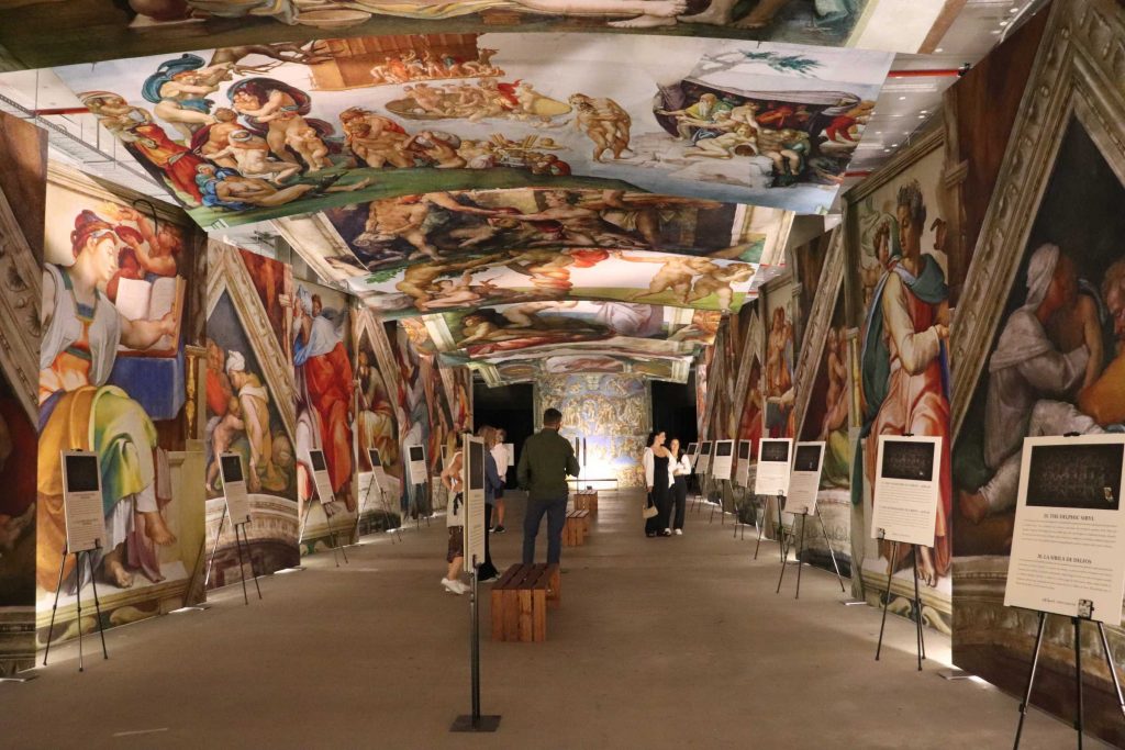 people looking at high def images of sistine chapel exhibition