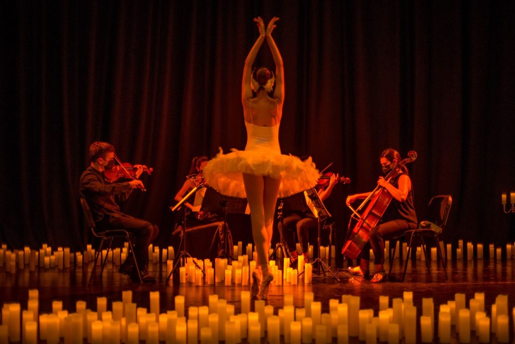 ballerina surrounded by candles in front of a string quartet