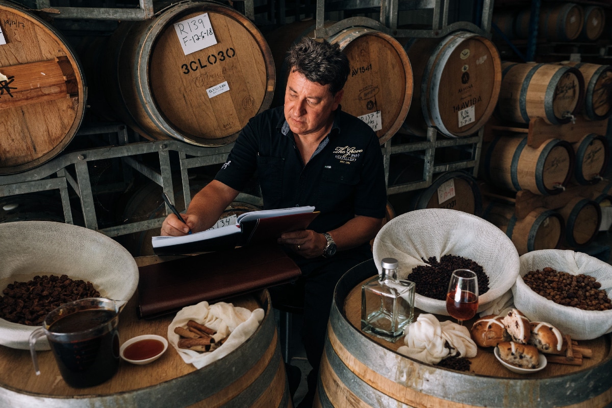 a photo of a man in front of rum barrels