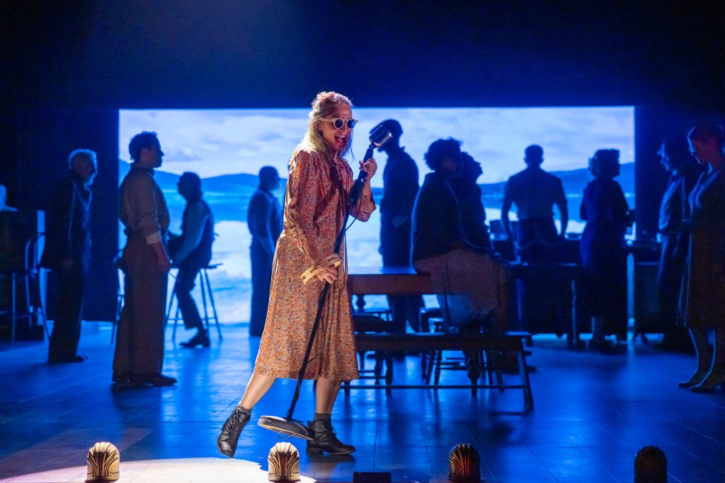 lisa mccune on stage dancing with microphone and shades on as part of girl from the north country production