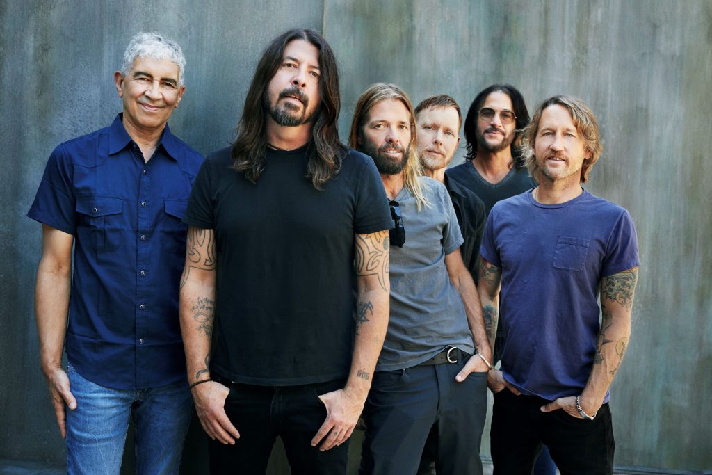 the members of foo fighters standing with their hands in their pockets