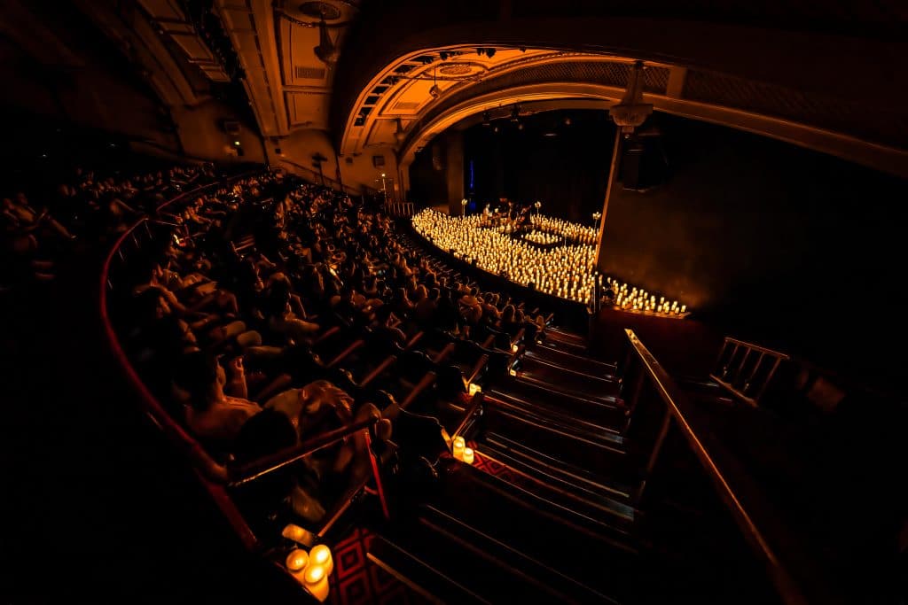 national theatre melbourne lit up with thousands of candles with performers on stage