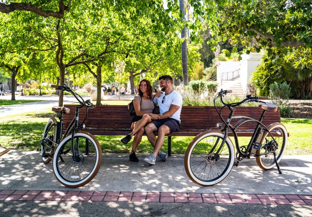 Couple sitting on a park bench after enjoying their bike ride