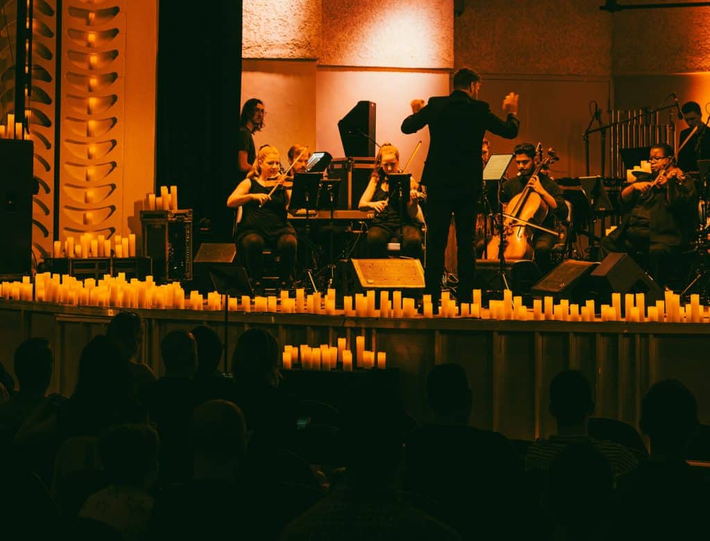 orchestra performing on candlelit stage
