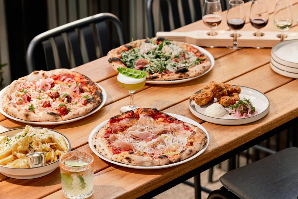 a selection of pizza and alcoholic drinks on a table
