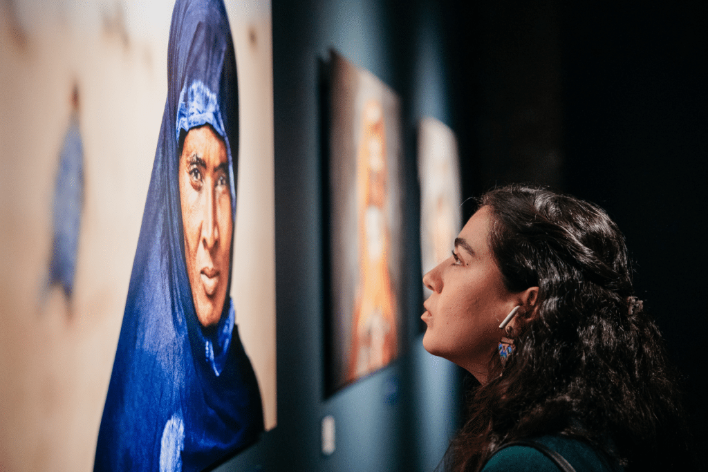 Woman looking at a portrait at the Steve McCurry ICONS Exhibition
