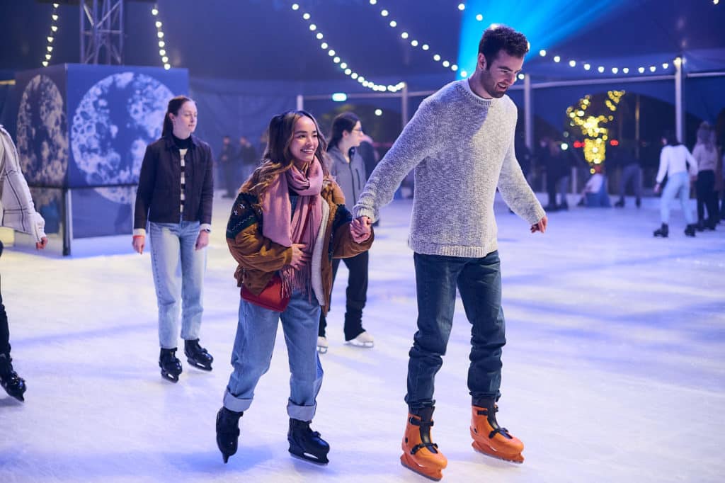A couple ice skating at the rink at rising 