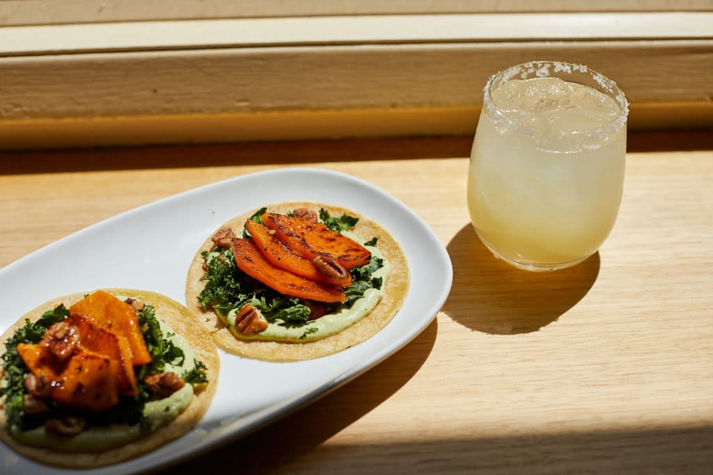 A plate of tacos and a margarita by a window at Mamasita, one of Melbourne's best Mexican restaurants.