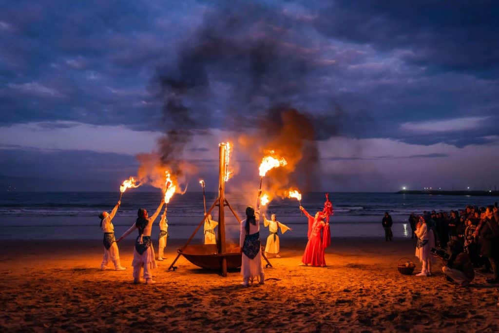 people dancing around a fire on a beach at WinterWild
