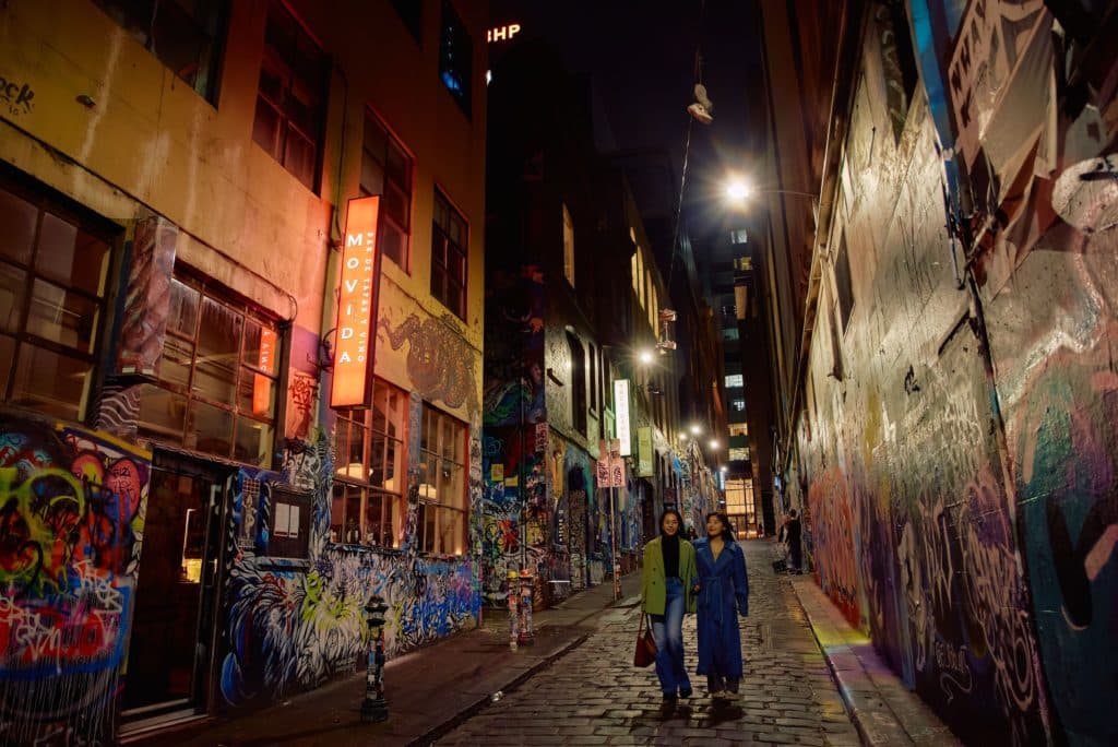 two women walking down the graffiti-filled Hosier Lane, next to MoVida, one of the Spanish restaurants to try in Melbourne
