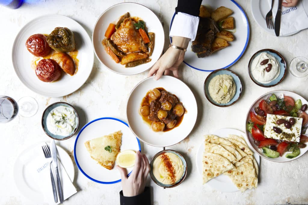 a selection of greek food on a white table at Stalactites, one of the Greek restaurants in Melbourne