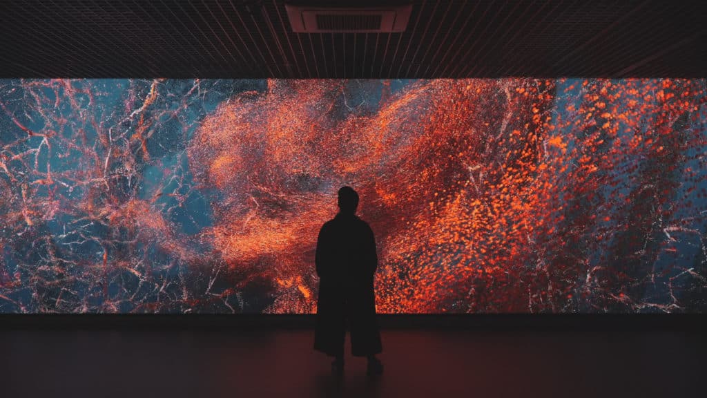 a silhouette of a man standing in front of red digital art