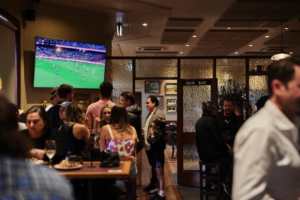 people dining at chatting, watching the footy at Orrong Hotel