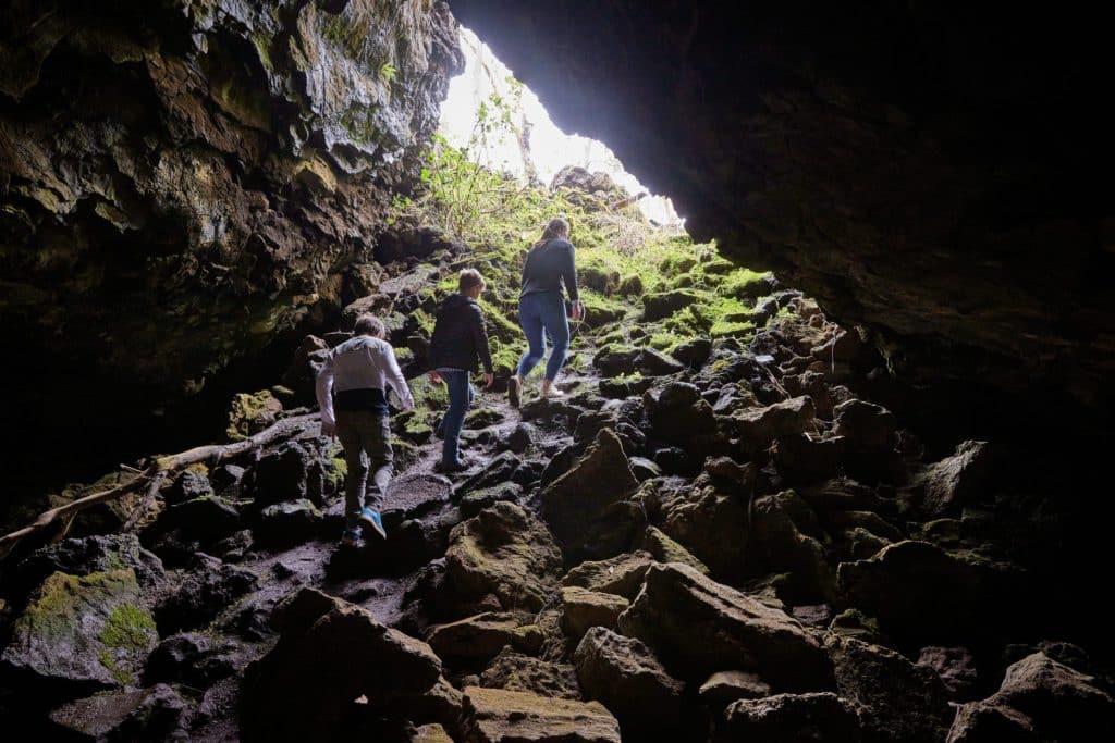 people emerging from a cave