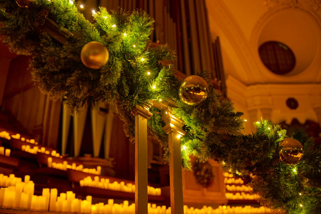 A staircase decorated with a Christmas wreath and countless candles