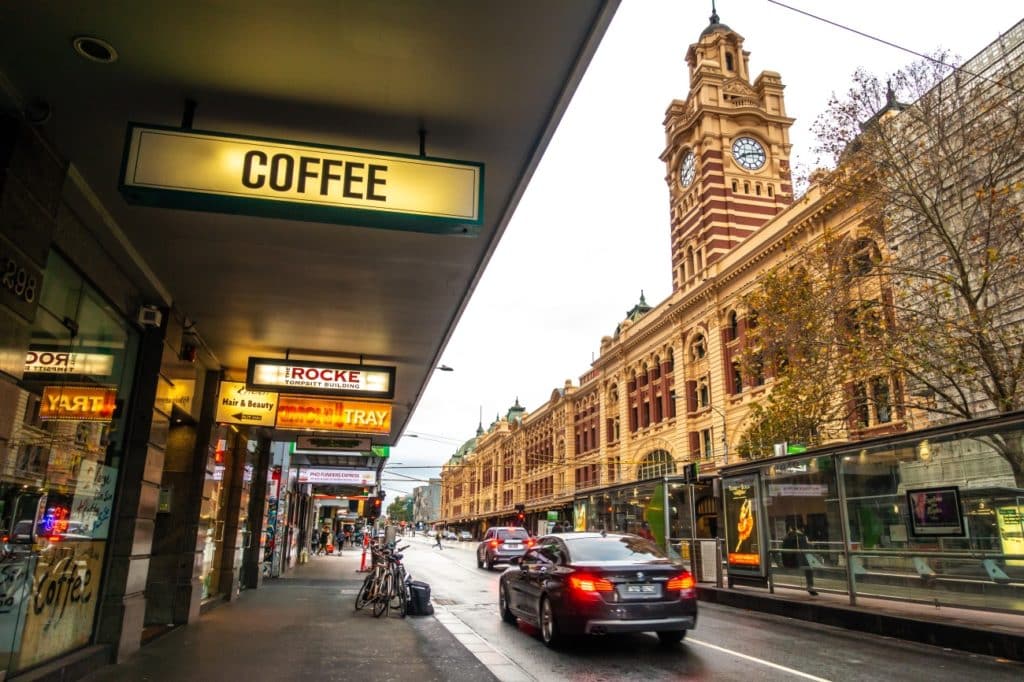 An illuminated sign reads 'coffee' outside of Flinders Street Station in Melbourne.