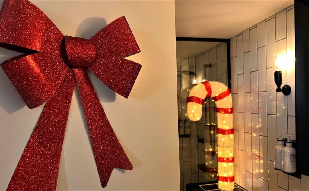 an oversized bow and an illuminated candy cane inside a hotel room