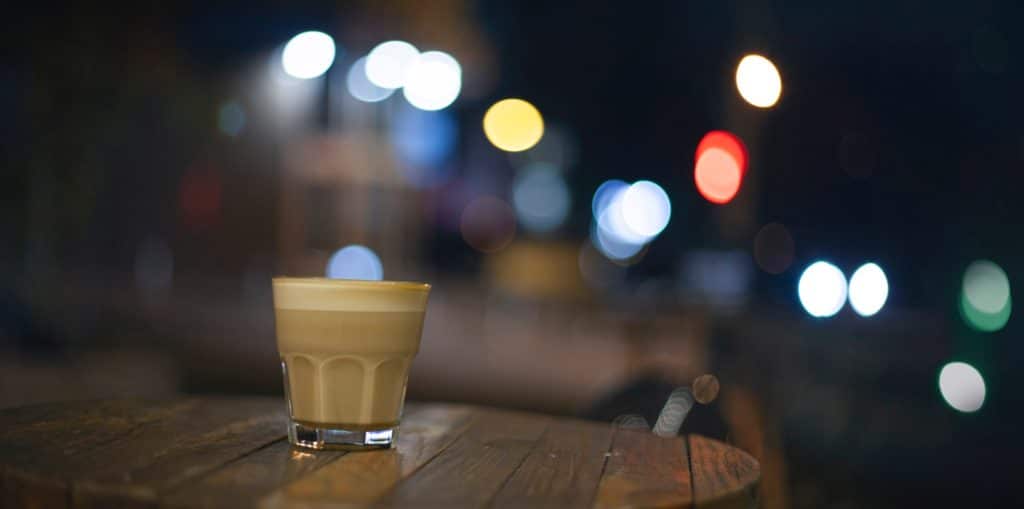 a flat white on a table at night
