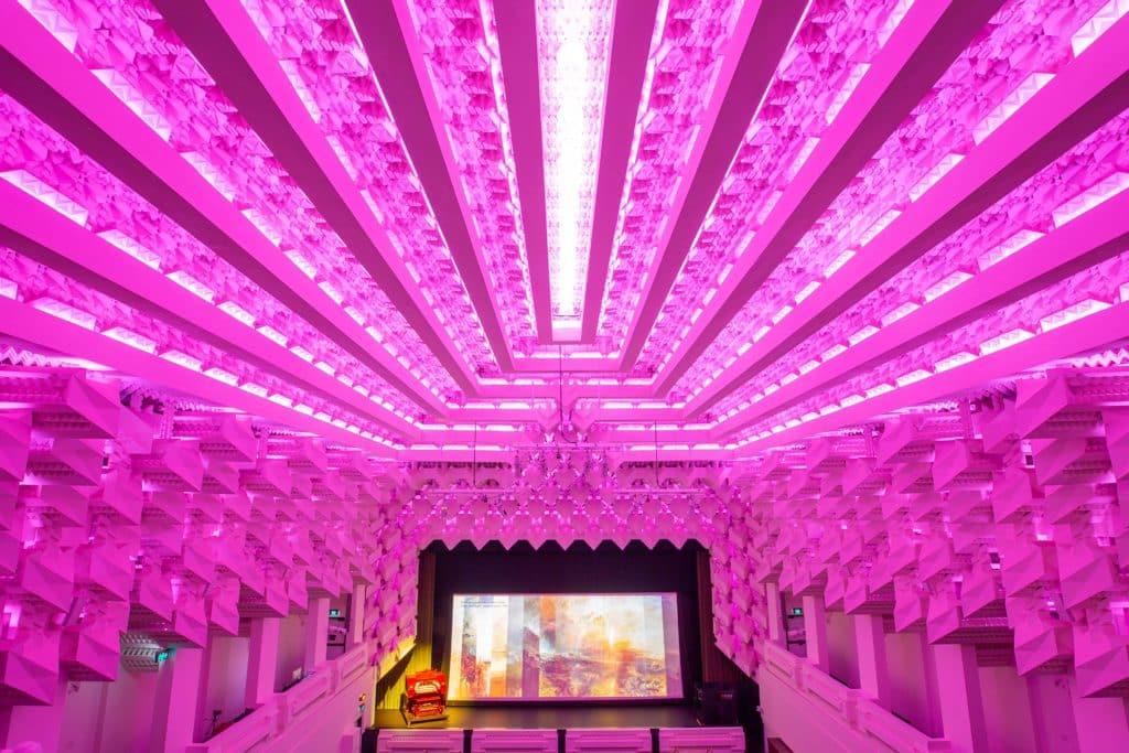 the inside of a cinema, lit up in pink
